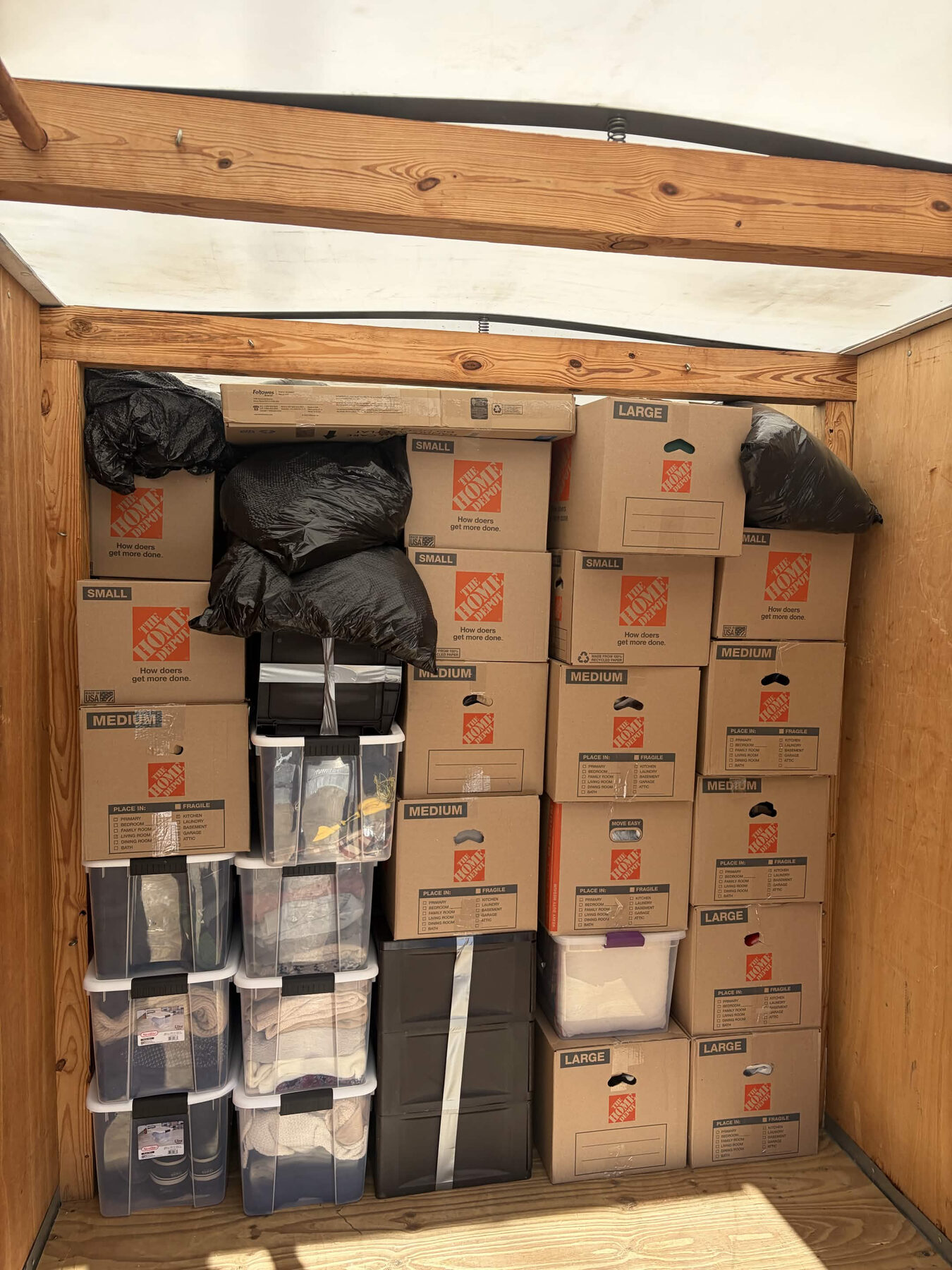 Moving boxes and household items secured inside a truck.
