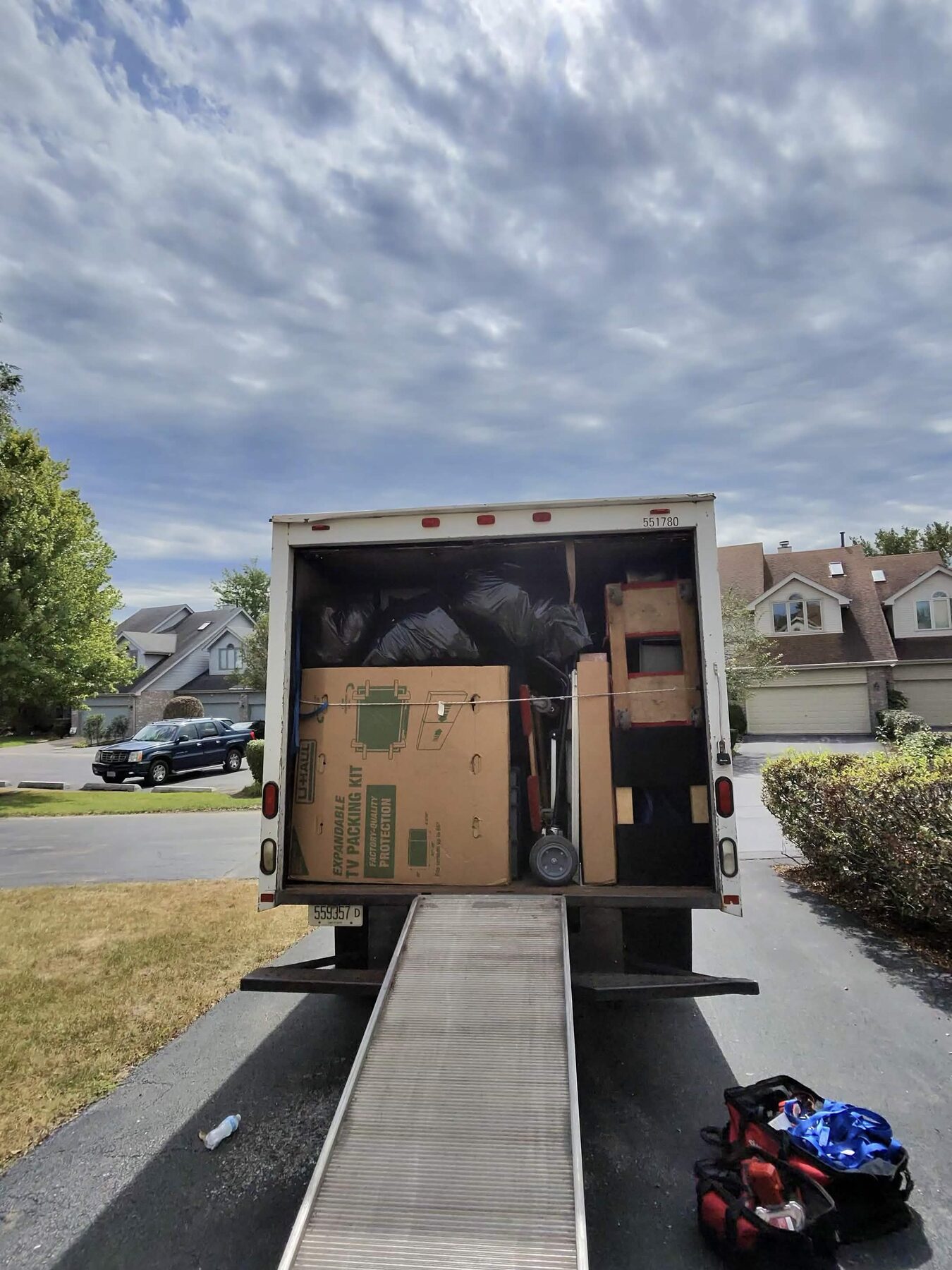A moving truck loaded with furniture and boxes in a residential neighborhood.